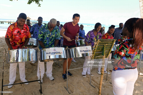Chee Lee, a cast member of the AMAZING RACE 2020, is pictured in Tobago learning to play the steel pan with Redemption Sound Setters in 2018